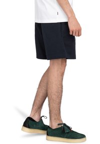 Marina shorts i bomull med en avslappnad passform. Bärs tillsammans med gröna mockaskor med svarta detaljer och lätta gummisålar.
