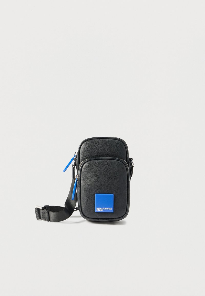 Μικρό μαύρο δερμάτινο τσαντάκι χιαστί με μπλε φερμουάρ και μπλε λογότυπο με την επιγραφή "KARL LAGERFELD JEANS" στην μπροστινή τσέπη.