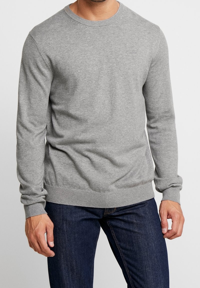 Grauer gestrickter Pullover mit langen Ärmeln, Rundhalsausschnitt und gerippten Bündchen und Saum. Glatte Textur, mit einem dezenten Logodetail auf der Vorderseite.