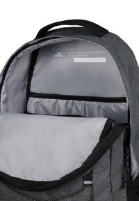 Harmaa kangaskassi, jonka sisällä on tilava pääosasto ja pienempi vetoketjullinen tasku. Likaa hylkivä materiaali ja heijastavat yksityiskohdat.