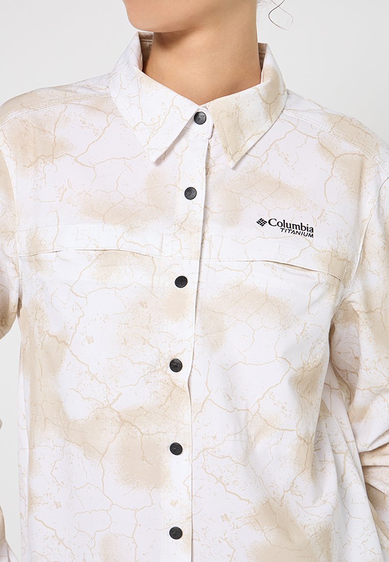 Hemd mit Kragen und langen Ärmeln in Weiß mit beigem Crackle-Muster. Verfügt über schwarze Knöpfe und ein Columbia Titanium-Logo auf der Brusttasche.
