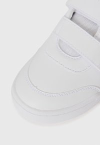 Baskets blanches avec une tige en cuir lisse et des accents en mesh, des bandes auto-agrippantes et un bout arrondi. Une couture subtile ajoute de la texture.
