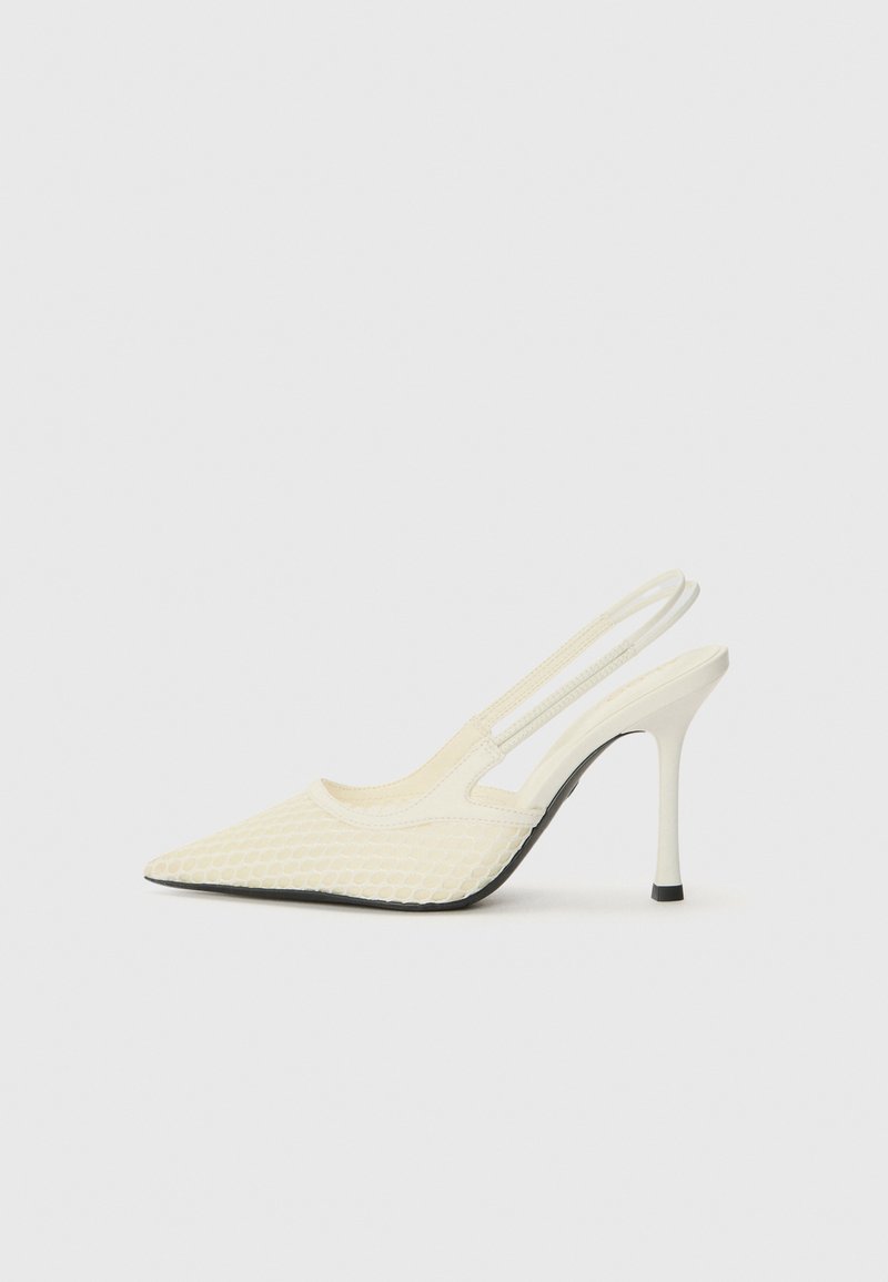 Slingback heel dengan ujung runcing dalam bahan tekstur krem, menampilkan pola mirip jala dan hak tinggi yang ramping. Sol karet hitam.