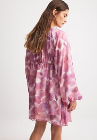 Paarse bloemenjurk van lichtgewicht, doorschijnende stof met luchtige mouwen en een elastische tailleband, met een zachte, vloeiende uitstraling.