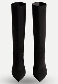 Bottes noires au-dessus du genou en daim doux avec un bout pointu et une texture lisse, présentant un design ajusté et sans couture.
