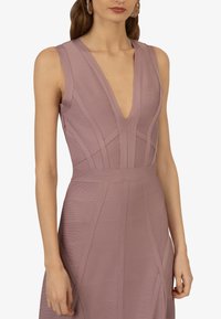 Lila ärmelloses Kleid mit tiefem V-Ausschnitt, das strukturierte, vertikale Nahtdetails und eine taillierte Silhouette aufweist. Glattes, strukturiertes Material.