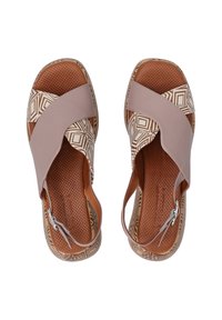 Braune Sandalen mit einem Kreuzband-Design in helltaupe, geometrischem Muster auf dem Obermaterial und einer strukturierten braunen Sohle mit Perforationen.