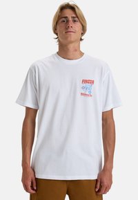 Witte katoenen t-shirt met een rood en blauw grafisch ontwerp op de borst met de tekst "FINZZA" en golven eronder, losse pasvorm en korte mouwen.