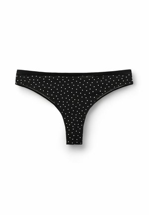 Black thong underwear with white polka dots, soft fabric, and thin waistband. Features a triangle shape with minimal coverage.