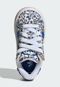 Floral-patterned sneaker with white canvas, blue accents, and white laces. Rubber sole with textured finish. Branding visible on the tongue.