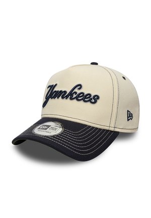 Beige and black adjustable baseball cap with "Yankees" embroidered on front and New Era logo on side and sticker on the brim.