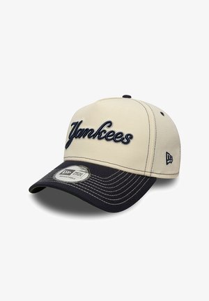 Beige and black adjustable baseball cap with "Yankees" embroidered on front and New Era logo on side and sticker on the brim.