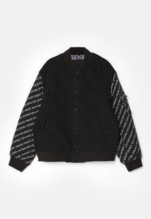 Jachetă bomber neagră cu textură matlasată, având un corp solid și mâneci contrastante cu un model de text alb, cu manșete și guler ribbați.