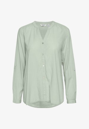 Lys grøn skjorte med knaplukning og lodrette striber, slim krave, lange ærmer og mulighed for at rulle ærmerne op. Blødt stof med en afslappet pasform.