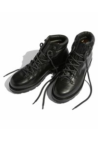 Botas de senderismo de cuero negro con punta redondeada, cuello acolchado y suelas de goma duraderas. Presenta ojales de metal y cordones trenzados.