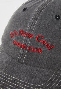 Căciulă din bumbac gri cu text brodat roșu "It's Now Cool RIDING CLUB." Prezintă cusături albe contrastante și o vizor curbat.