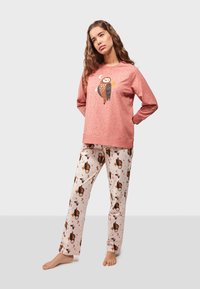 Pink sweatshirt with owl print and dot pattern, paired with beige pants featuring owl and star motifs, made from soft fabric.