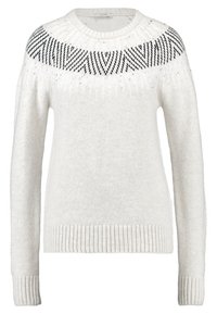 Vit stickad tröja med långa ärmar, prydd med ett geometriskt svart mönster runt halsringningen. Mjuk textur och ribbade mudd.