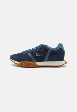 Tenis atléticos azul marinho com sola de borracha texturizada, parte superior em camurça e tecido, detalhes em azul claro e um pequeno logo bordado na lateral.
