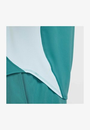 Haut de sport turquoise avec des accents bleu clair et une finition texturée. Présente un ourlet incurvé et des coutures contrastées.