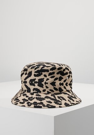 Beige bucket hat met onregelmatig zwart luipaardprint patroon weergegeven op witte ondergrond.