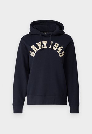 Navy blue hooded sweatshirt made from soft fabric. Features a kangaroo pocket, ribbed cuffs, and contrasting "GANT 1949" embroidery across the chest.