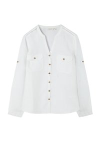 Blouse blanche à manches longues avec boutons sur le devant, deux poches poitrine à rabats boutonnés, et pattes boutonnées sur les manches pour les retrousser.