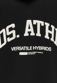 Schwarzer Kapuzenpullover mit weißem Text: "OS. ATHL VERSATILE HYBRIDS." Mit einem Etikett mit der Aufschrift "ENTWICKLUNGSMUSTER F/W 2024/25." Sanfte Textur.