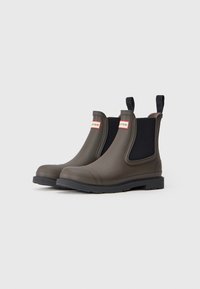 Bottes Chelsea en caoutchouc vert foncé avec des panneaux latéraux élastiques noirs et des languettes de tirage. Dispose d'une semelle texturée pour l'adhérence. Marque rouge sur les côtés.