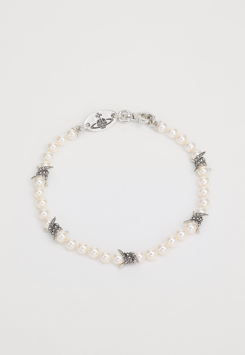 Bracelet en perles avec accents en argent, présentant de petits éléments décoratifs et une fermeture à clip. Texture lisse et forme ronde uniforme.