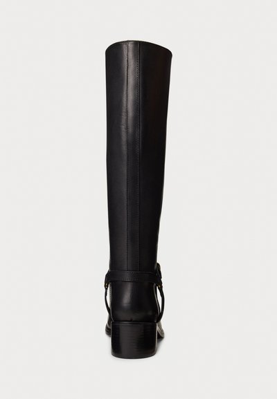 Black leather knee-high boot with low block heel and strap detail around the back, shown from rear view on white background.