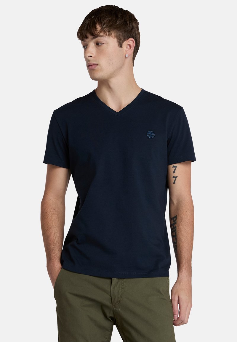 Námořnická modrá bavlněná tričko s V výstřihem, krátkými rukávy a malým světle modrým logem na prsou. Měkká textura, pohodlný střih.