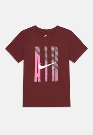 Mørkebrun bomulls t-skjorte med grafisk design i rosa, hvitt og stripete mønstre, samt en fremtredende Nike-logo i midten.