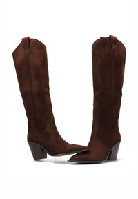Botas de gamuza marrón hasta la rodilla con puntera afilada, patrones de costura distintivos y tacones cuadrados, que presentan una textura suave y un diseño estructurado.