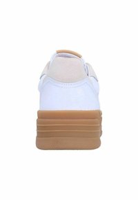 Witte sneaker met een tan rubberen zool, suede hielstuk en een gladleren bovenkant. Vlakke veters en een minimalistisch ontwerp zonder zichtbare logo's.
