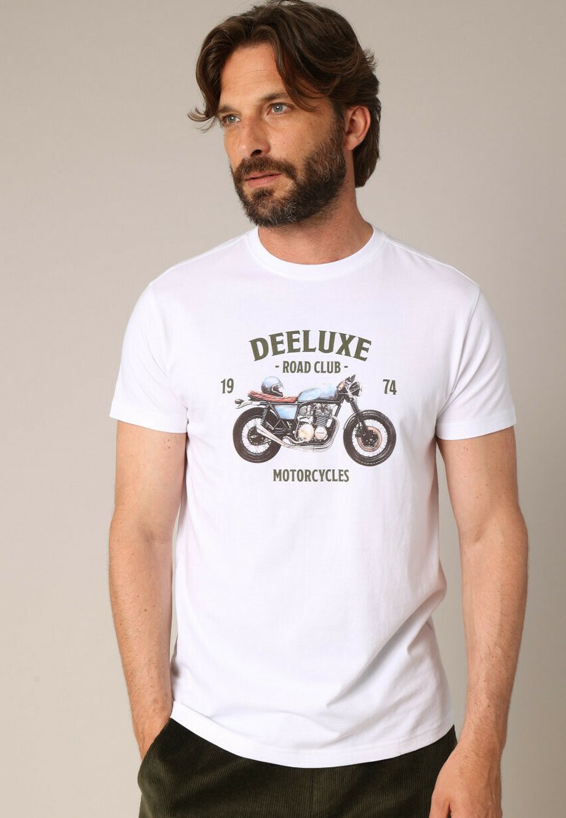 T-shirt en coton blanc avec un graphique de moto et le texte "DEELUXE ROAD CLUB 1974 MOTORCYCLES" en couleurs vertes et brunes.
