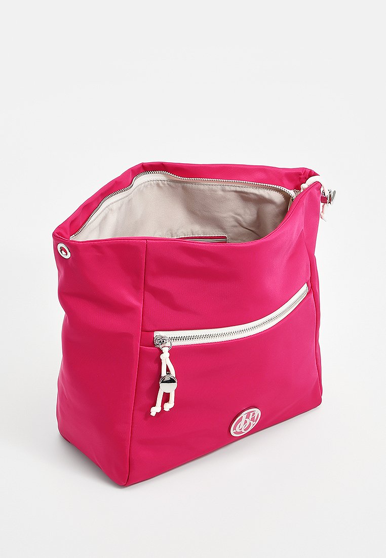 Leuchtend pinkfarbene Stofftasche mit beigem Innenfutter, vorderer Reißverschlusstasche mit weißem Reißverschluss und Kordelzug, runder silberner Logosticker auf der Vorderseite.
