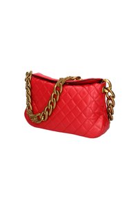 Borsa a tracolla in pelle trapuntata rossa con catena dorata, caratterizzata da una forma unica e una texture lucida. Nota per il suo colore vivace e i dettagli di design.