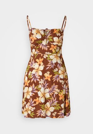 Smeđa cvjetna haljina s podesivim trakama, koja ima detalj s uzicom na grudima. Cvjetni uzorci u žutoj, narančastoj i ljubičastoj boji.