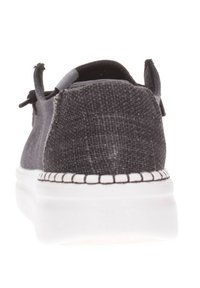 Scarpa in tessuto grigio scuro con superiore testurizzato, cuciture bianche lungo la suola e una suola in gomma bianca leggera. Stringhe sui lati.