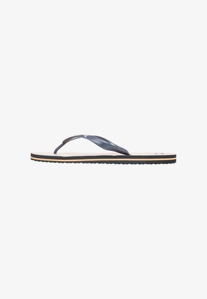 Des tongs avec une lanière en caoutchouc bleu foncé avec des détails texturés, une semelle intérieure beige clair et une semelle extérieure noire et striée.