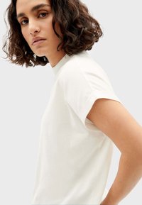 Wit katoenen t-shirt met korte mouwen en een ronde halslijn, met een ontspannen pasvorm en zachte textuur. Geen zichtbare patronen of logo's.