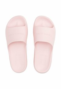 Infradito in gomma rosa chiaro con punta chiusa e tallone aperto. Presentano il logo "Tommy Jeans" impresso sulla fascia superiore. Tessuto liscio, design minimalista.