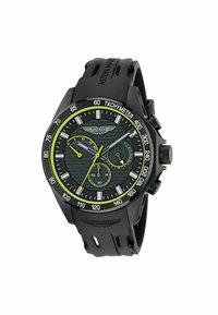 Černé chronografické hodinky s texturovaným černým ciferníkem, zelenými akcenty a tachymetrem. Mají gumový řemínek a logo Aston Martin.