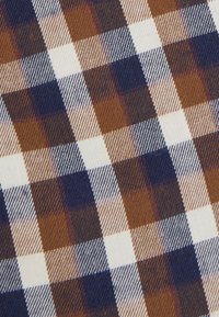 Design in tessuto a righe con quadrati alternati di marrone, crema e blu navy, con linee sottili che aggiungono texture e profondità al motivo.