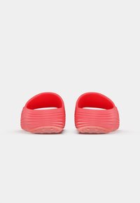 Ζευγάρι κόκκινων αναπαυτικών σανδαλιών με ριγωτή υφή, παρουσιασμένα από πίσω σε λευκό φόντο.