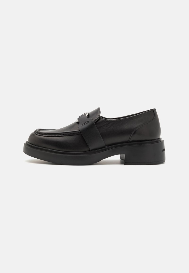 Black leather loafer with chunky sole, low block heel, and wide strap detail across the upper, on a white background.