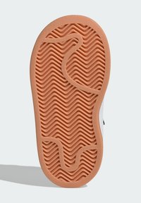 Rubber shoe sole with a textured, wavy pattern in brown. Features rounded edges and pronounced grip lines for traction.