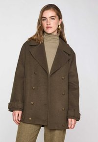 Cappotto peacoat in lana marrone con davanti doppiopetto, ampie rever e bottoni dorati. Presenta polsini arrotolati e una vestibilità morbida.