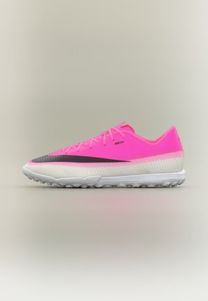 Φωτεινό ροζ και λευκό αθλητικό παπούτσι Nike με μαύρο λογότυπο Swoosh, χαμηλό προφίλ, κορδόνια και υφή στην σόλα για υπαίθρια χρήση.